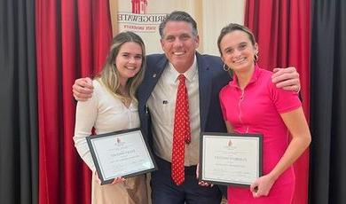 Kelsey and Elisabeth Sweeney receive sorority awards from President Clark.